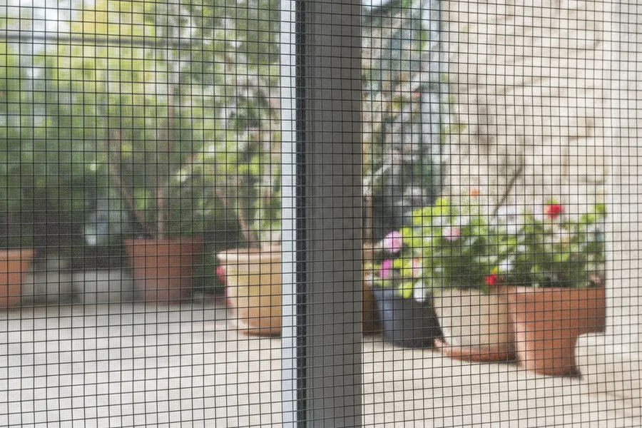 Mosquitera corredera con malla de fibra de vidrio en una puerta de terraza